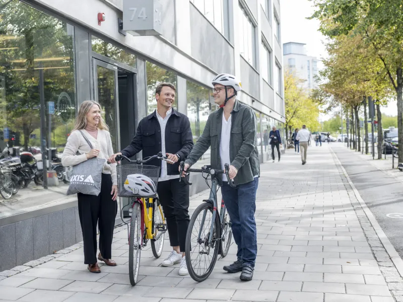 A group of Axis colleagues walking along the street with their bicycles.