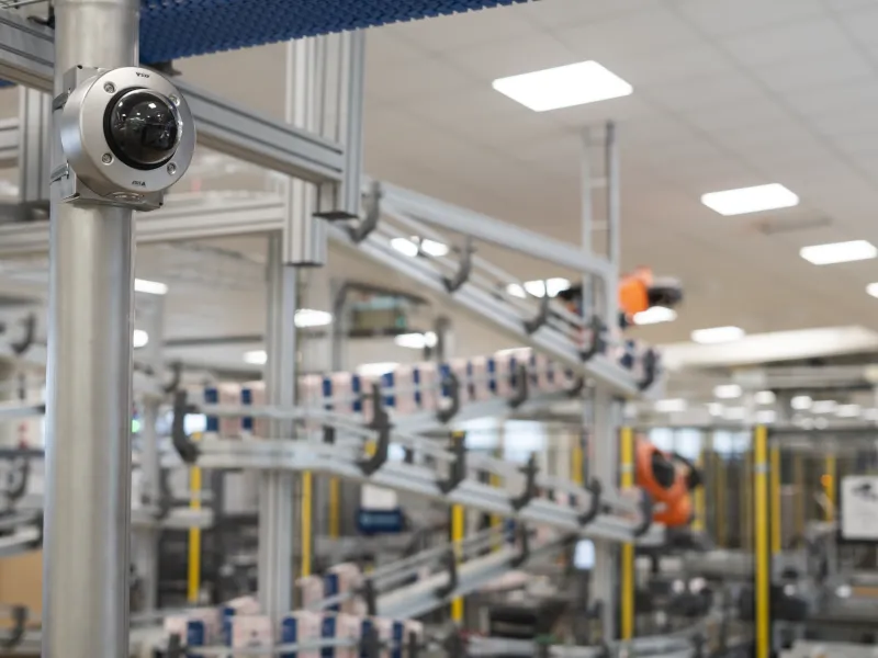 AXIS P3268-SLVE mounted on a metal pole inside a food processing plant.