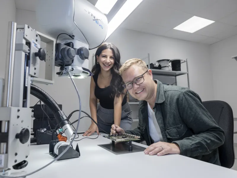 Axis colleagues Reem Chahrour Muhieddine and Jonas Lorander smiling during a collaborative session at a desk.