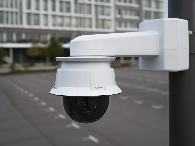 Image of AXIS T91G61 Wall Mount installed at a parking lot with AXIS Q6088-E PTZ Camera and AXIS TQ6907-E I/O LED Indicator