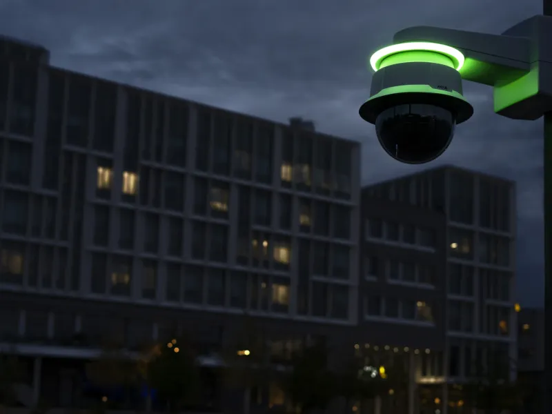 AXIS TQ6907-E I/O LED Indicator with AXIS Q6088-E PTZ camera and AXIS T94G61 Wall mount at dusk in a parking lot