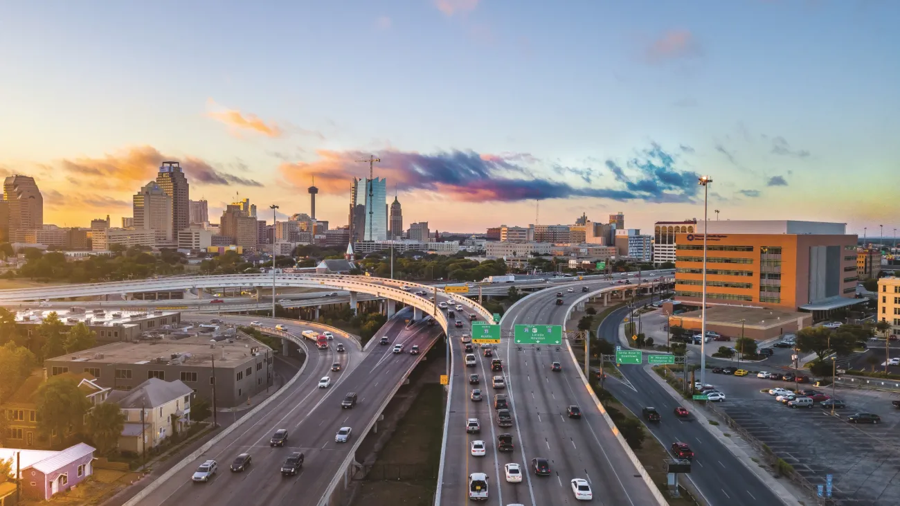 Overview of traffic roads in San Antonio with a sunrise behind.
