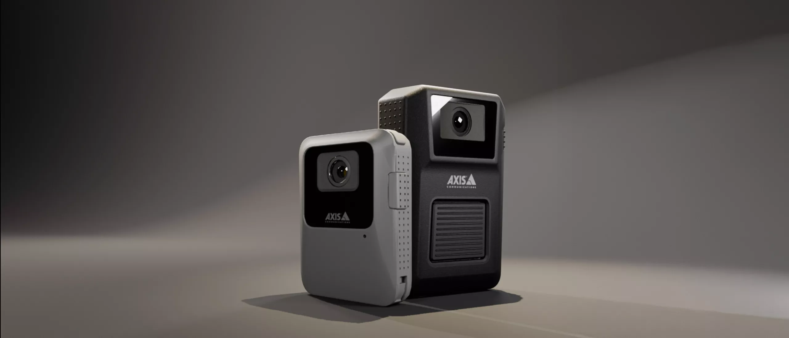Two Axis body worn cameras in the middle of a gray background.