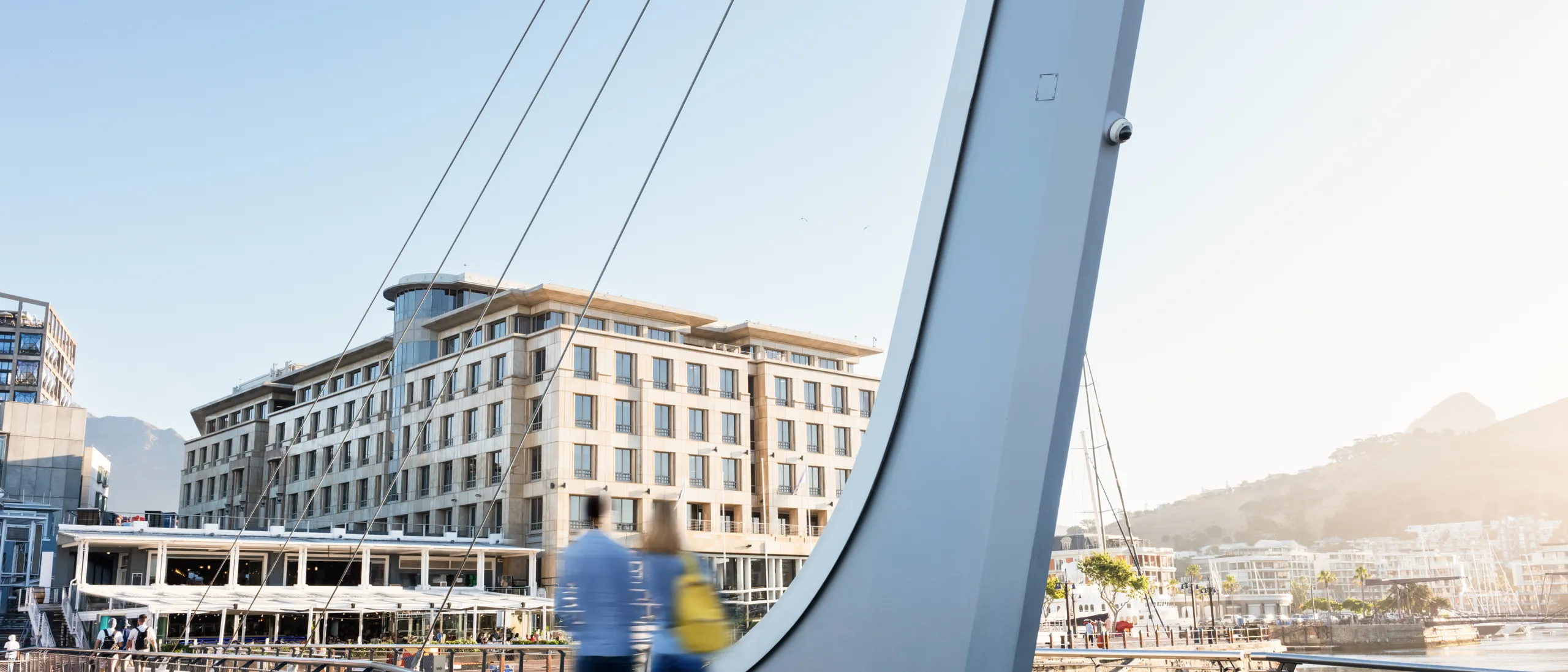 two people that are blurred walking on a bridge