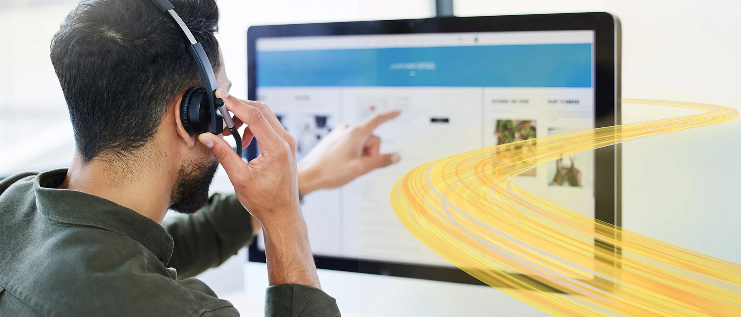Man talking on the phone while point at the computer screen