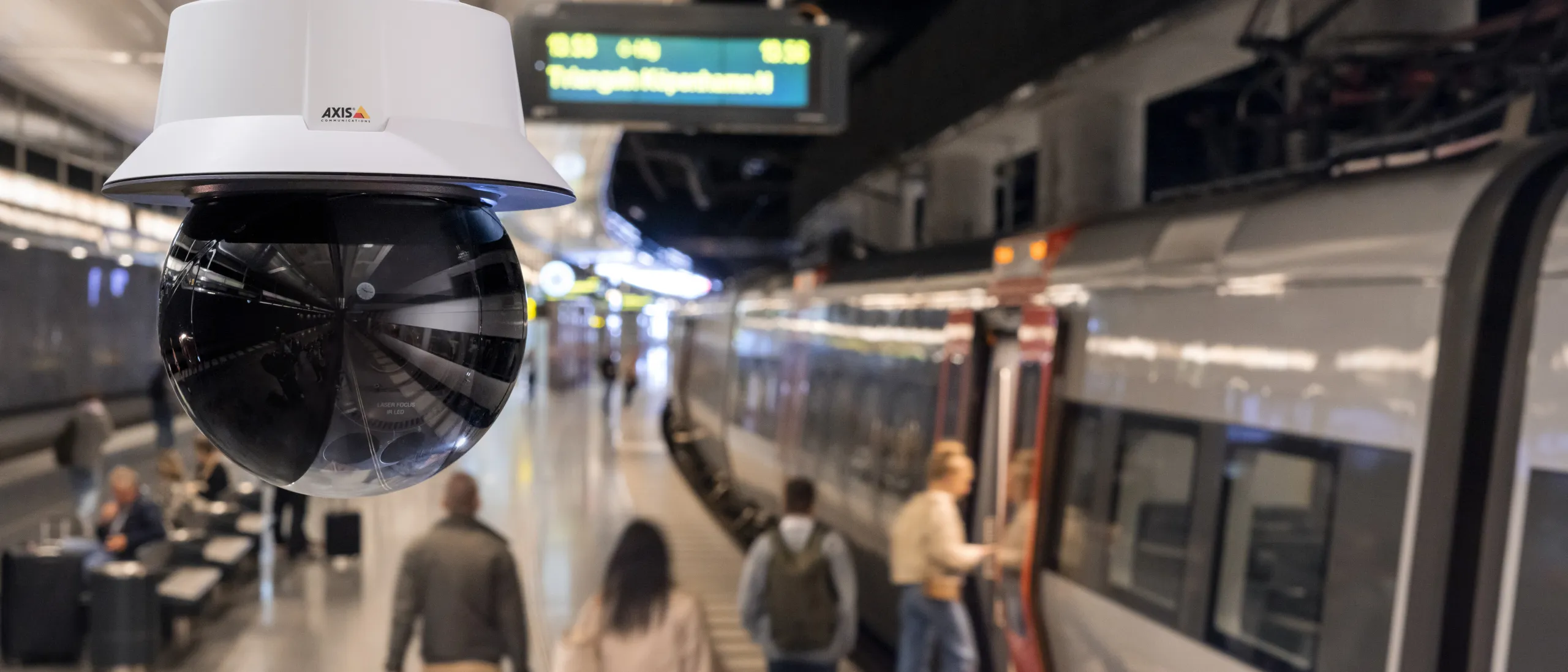 AXIS Q6318-LE mounted on the ceiling in a train station.