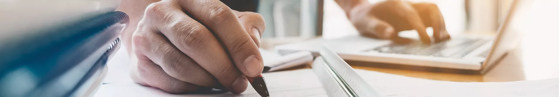 hand holding a pen over a technical drawing