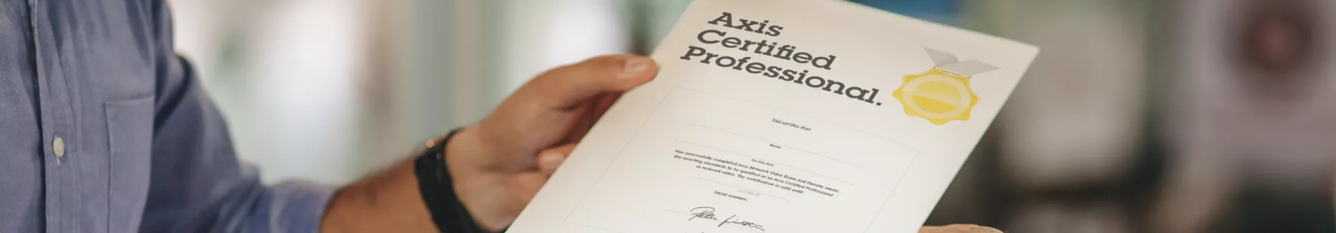 two hands holding a Axis Certified Professional certificate