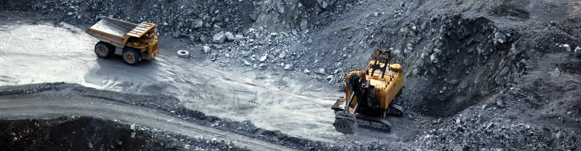 Dump trucks work in a open pit mining