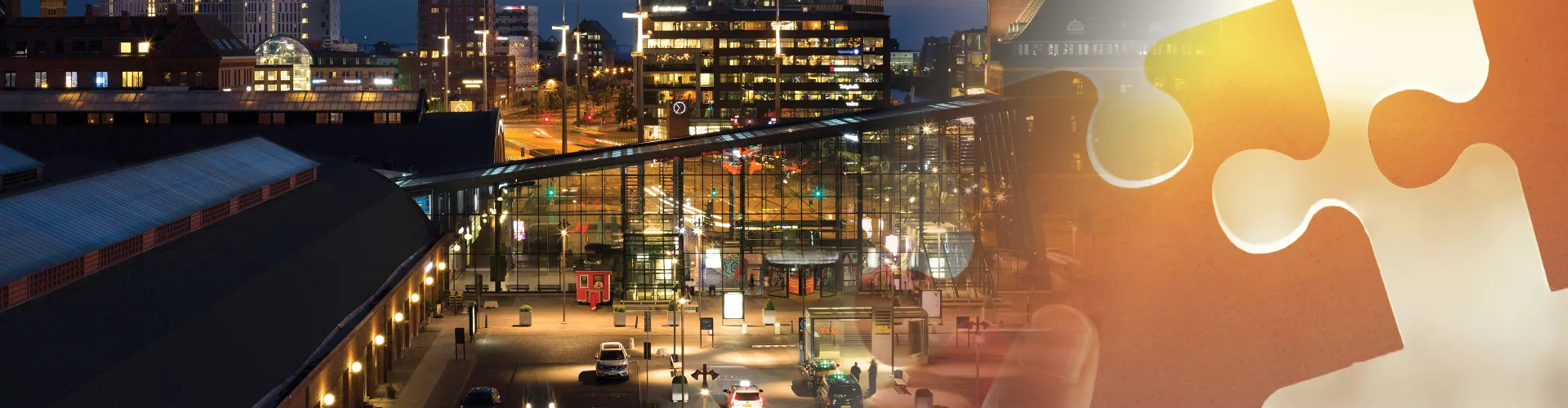 Malmö central station in the evening, looked from above. Taxi cars waiting outside.