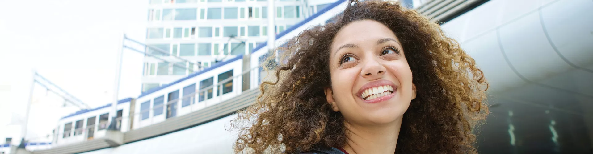 woman backpack smiling outside train station