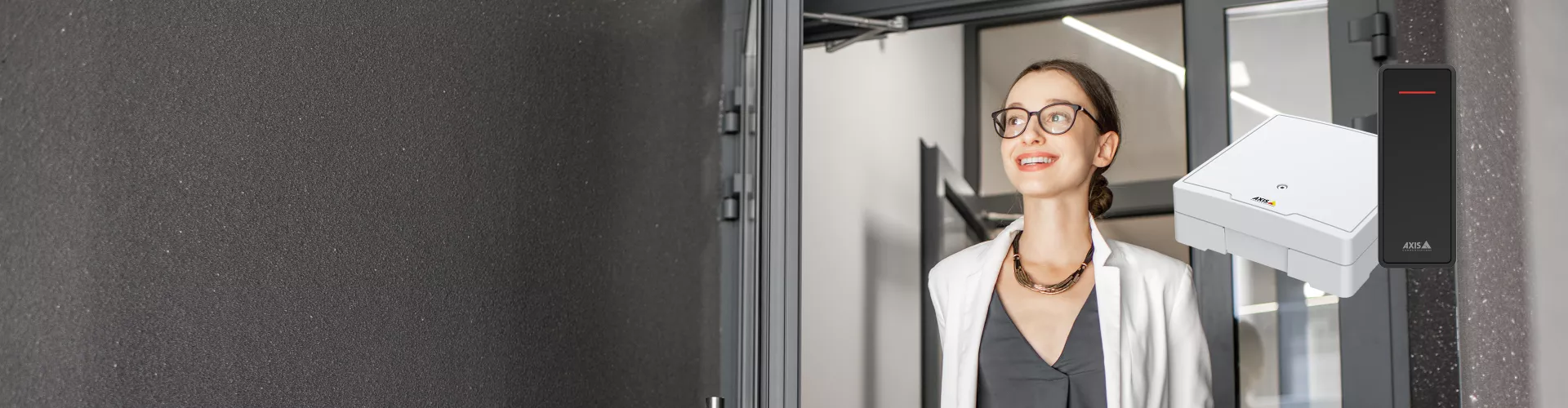 Person walking through a entrence door, wearning glasses and brown hair.