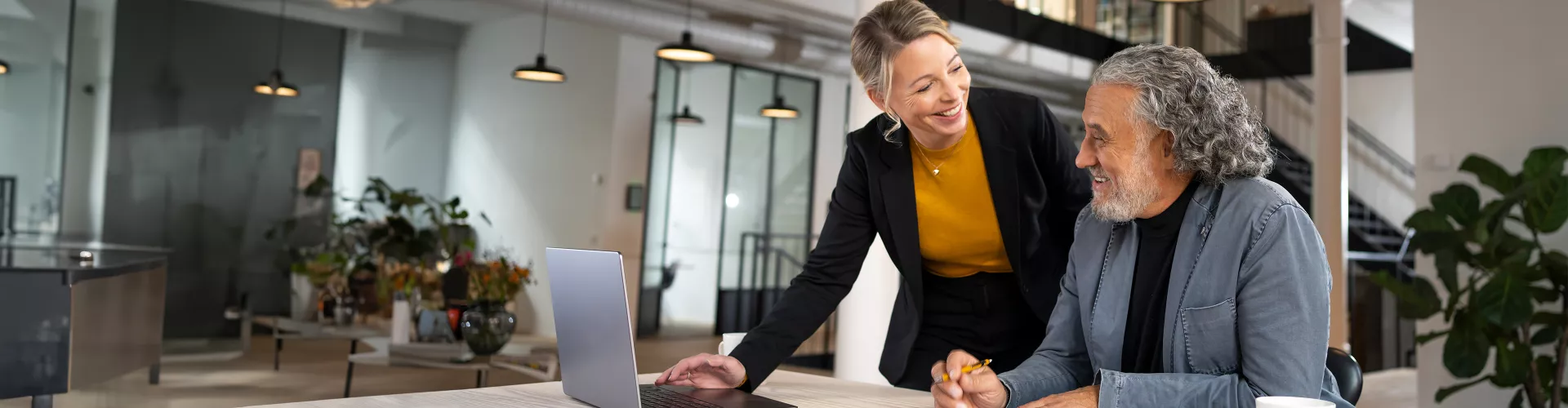 A&E woman and man collaborating on laptop in office