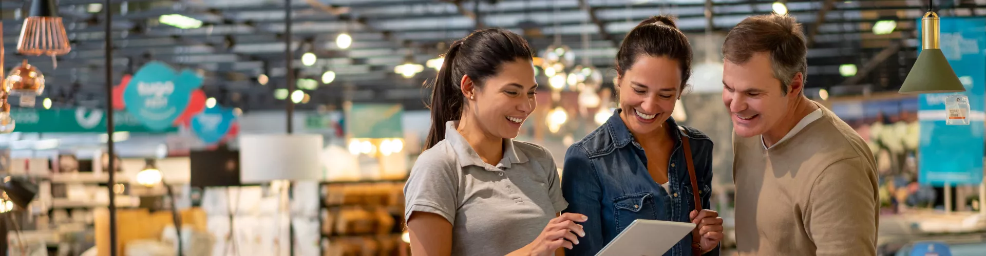 Couple shopping home furnishings with saleswoman's help