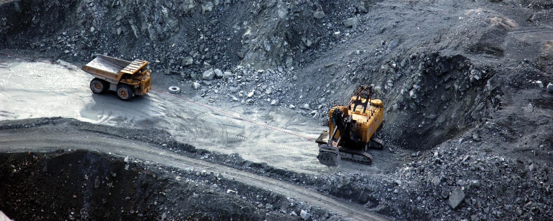 Dump trucks work in a open pit mining