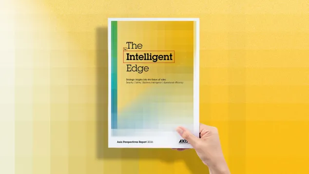 A hand holding a copy of "Axis Perspective" report in front of a yellow background.