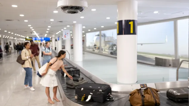 Woman picking up her bag from baggage claim in an airport.