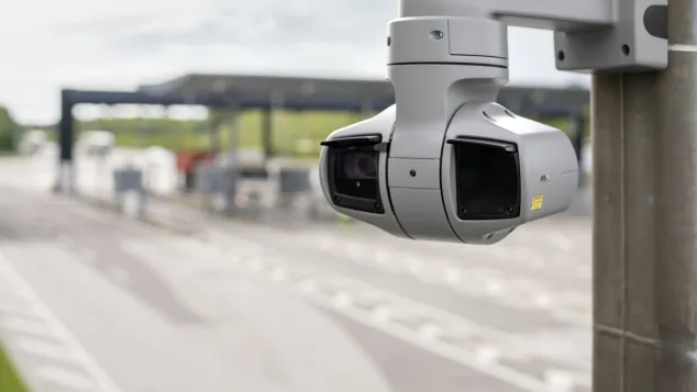 AXIS Q6225le mounted on a wall outside a toll station.