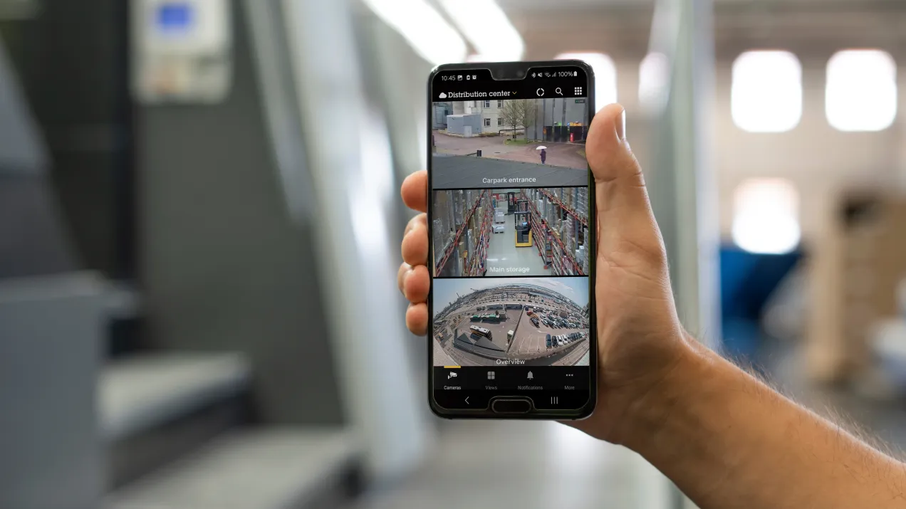 A phone held by a person to show AXIS Camera Station Pro's features all in one place.