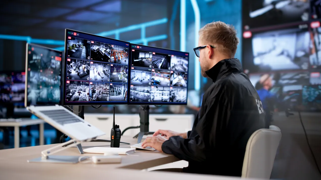 An operator looking at a multiple screens and a CCTV system