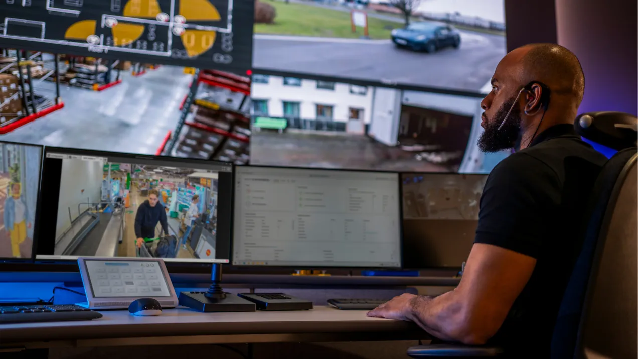 Security guard viewing monitors that shows live footage of a retail store.