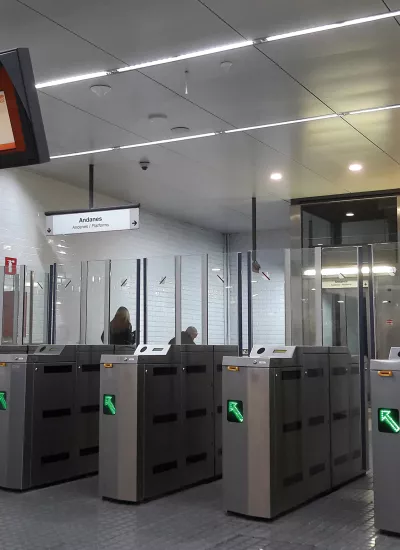 Public transportation gate access with green arrows.