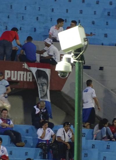 Stadium with blue seats and Axis Camera on a pole.