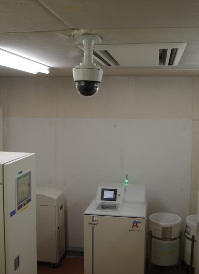 Axis camera on ceiling, system control room with white lockers.