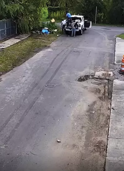 Screenshot of people in car performing illegal dumping of trash by roadside.