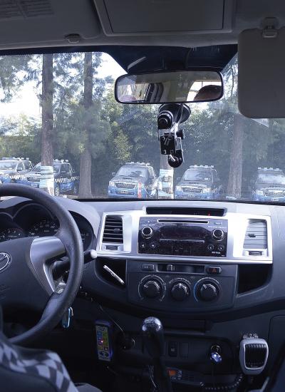 Inside a toyota car with two passengers viewing at several cars in front.