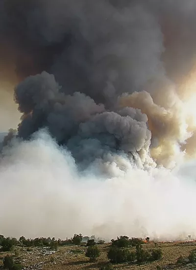 Smoke cloud over green landscape
