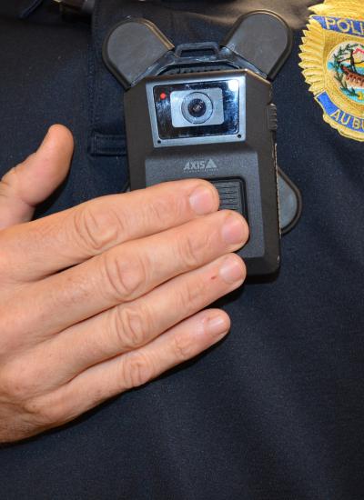 Close up of officer pushing button on Body Worn camera