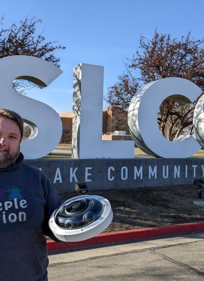 Security director holds Axis camera in front of Salt Lake Community College