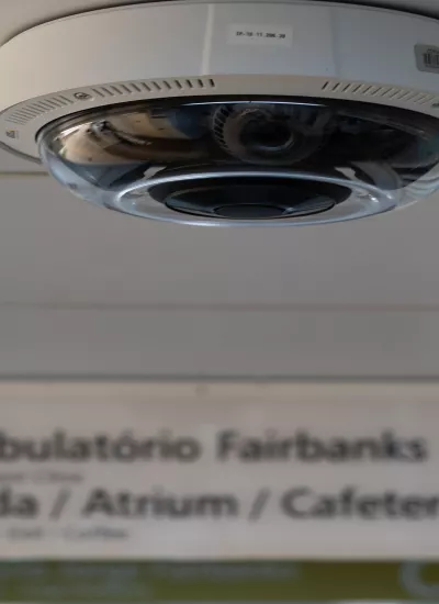 Ceiling camera in foreground with hospital sign in background