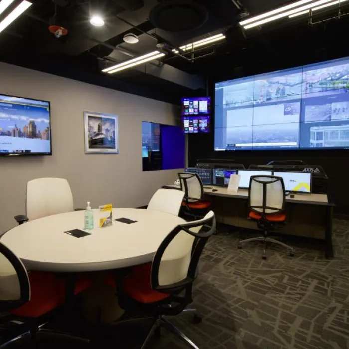 AEC in Chicago with chairs, a table and screens on the wall.