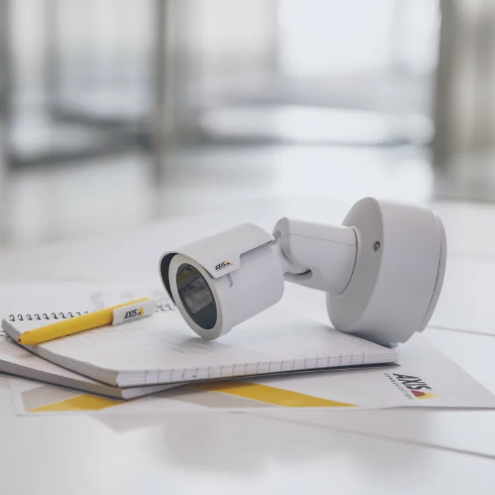 Axis camera and a pen and a paper lying on the desk with yellow overlay