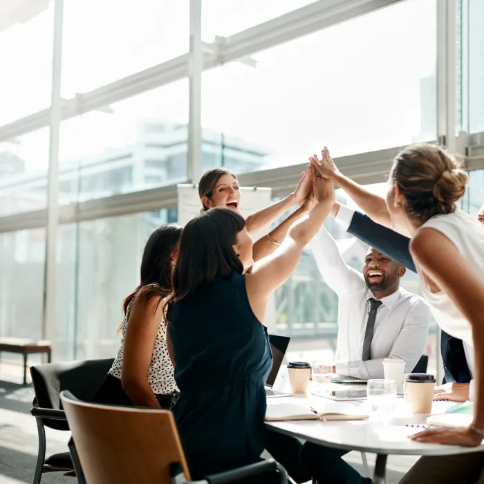 Business people high fiving in meeting.