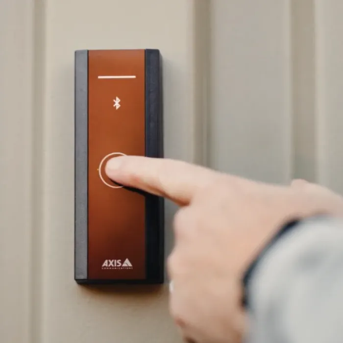 Finger pressing button on AXIS A4612 Network Bluetooth® Reader