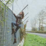 woman climbing on a fence
