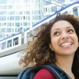 woman backpack smiling outside train station