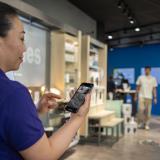Woman looking at phone with ACS Edge in a retail store