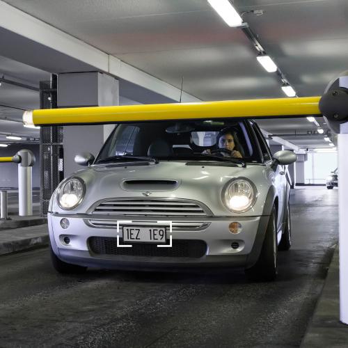 Car in a parking garage infront of a yellow boom