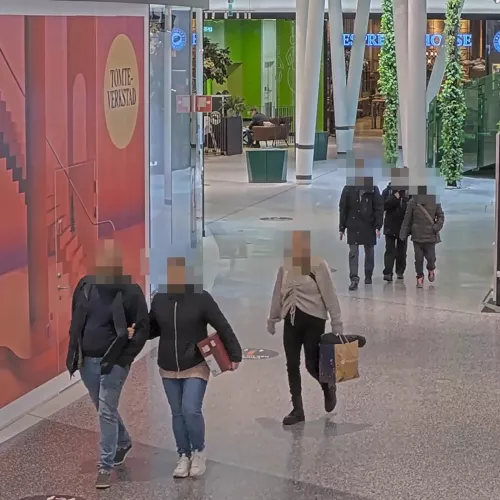 Personen im öffentlichen Raum, bei denen mithilfe von AXIS Live Privacy Shield die Gesichter bewusst unkenntlich gemacht wurden.