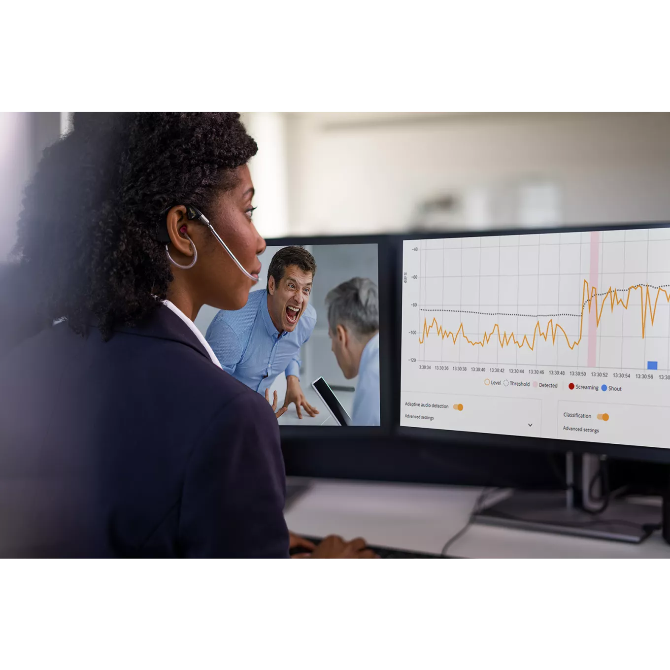 woman monitoring two screens