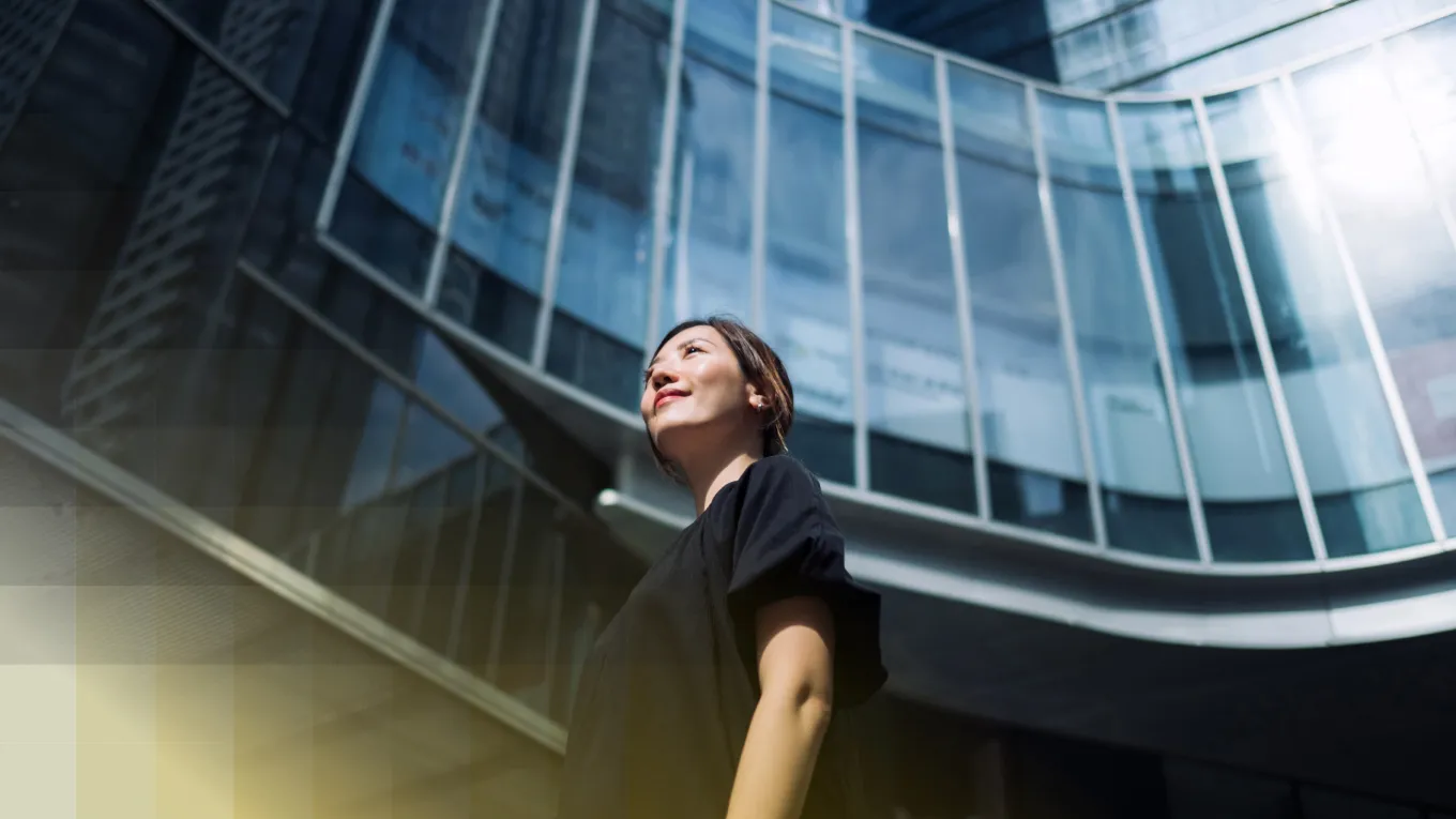 Asian woman looking up towards buildings