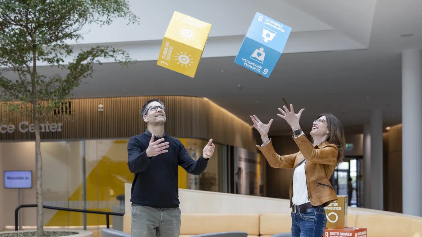 Carl Trotzig and Jeanette Skjelmose are seen throwing cubes with FN global goals written on them. 