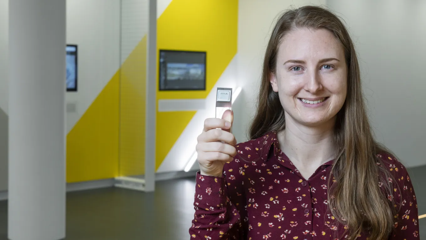 Malin Heyden holding up a ARTPEC chip