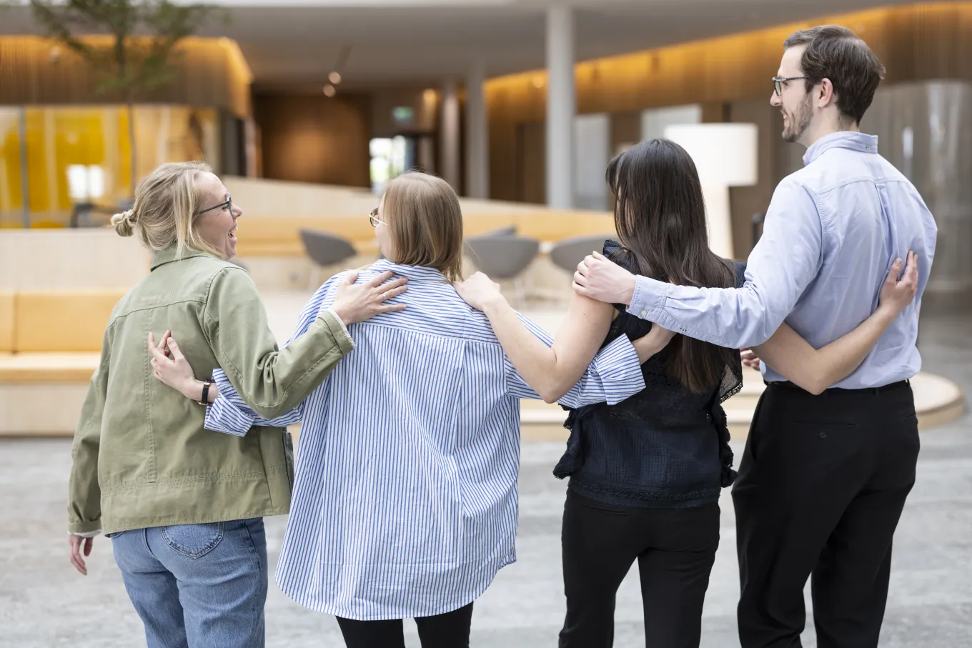 Stina Stadig, Ramona Berger, Rebecca Jonsson and Markus Richter standing in a line with their arms around each other's shoulders 