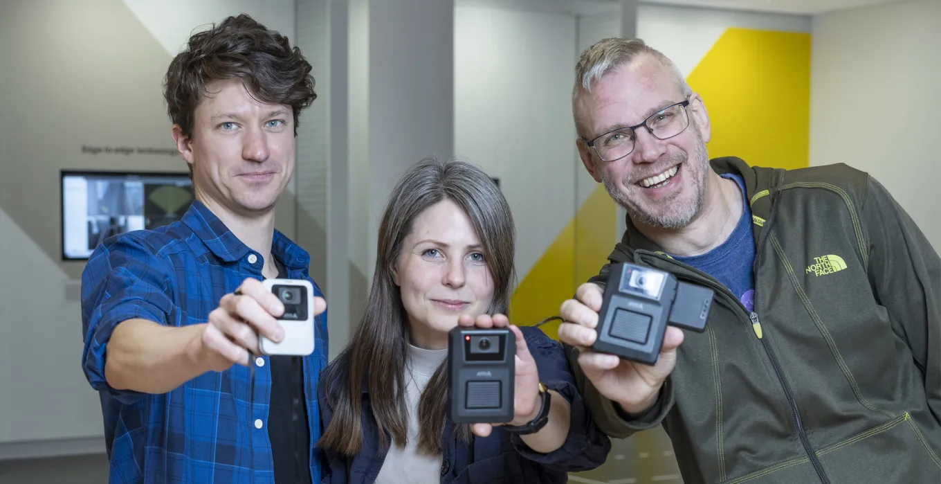 Johanna, Filip and Fredrik holding up bodyworn cameras 