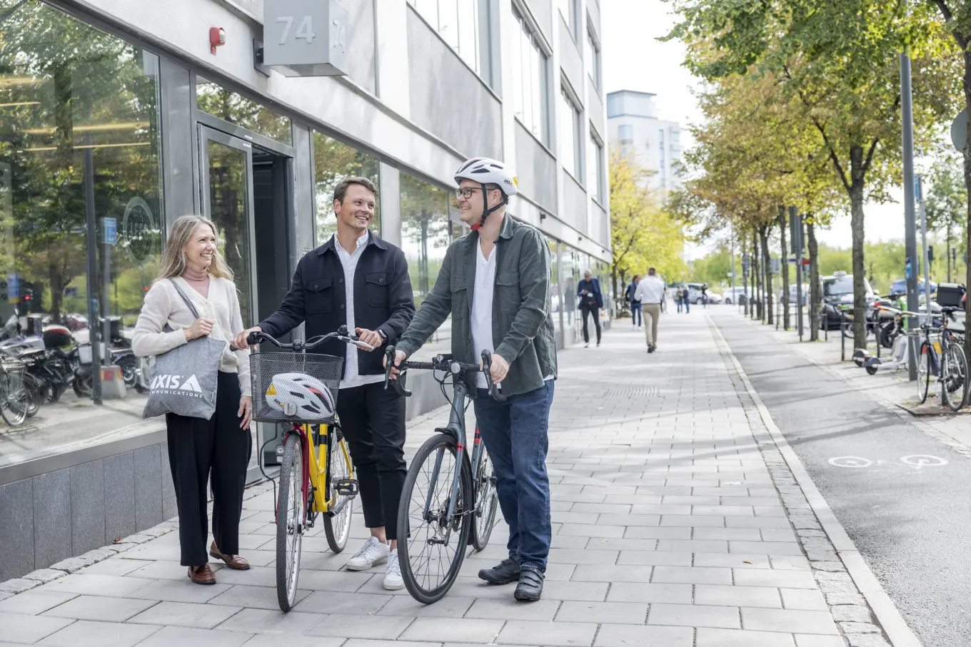 A group of Axis colleagues walking along the street with their bicycles.